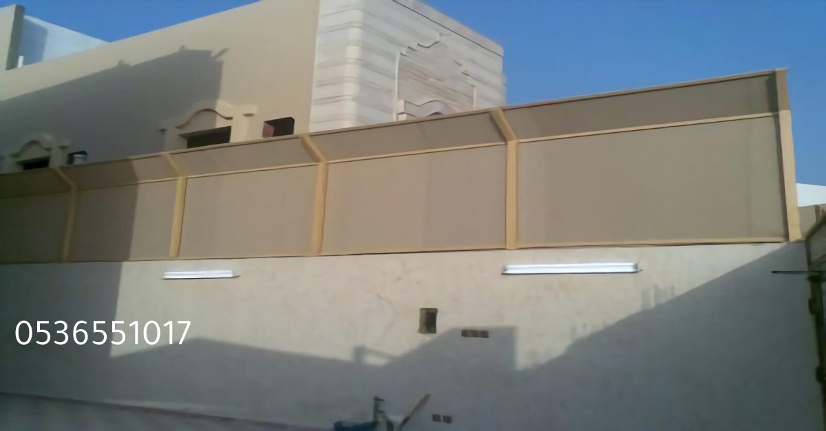 ساتر قماش بي في سي مشدود على سور خارجي لتوفير الخصوصية